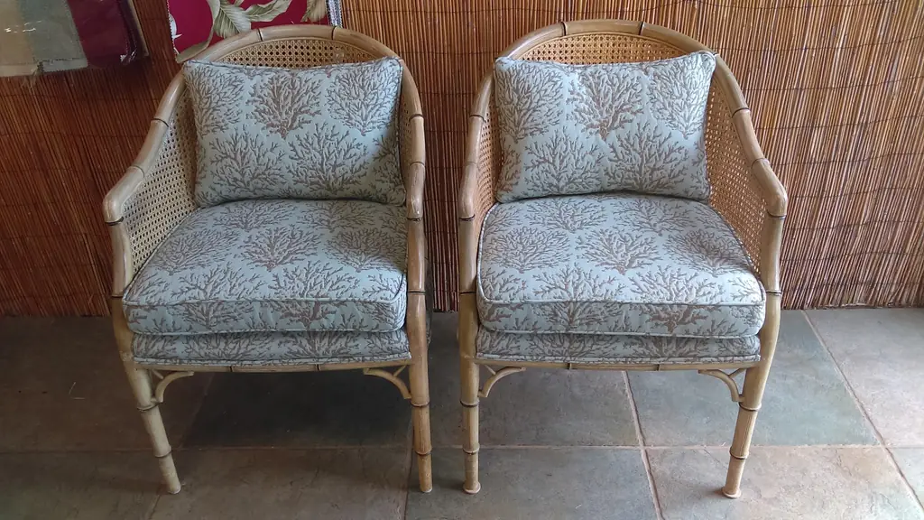 A pair of bamboo and cane barrel chairs re-covered in aqua coral-print fabric with piped seat and back cushions